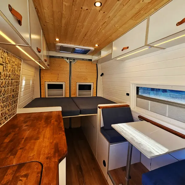 Salón y cama de una camper con dos claraboyas