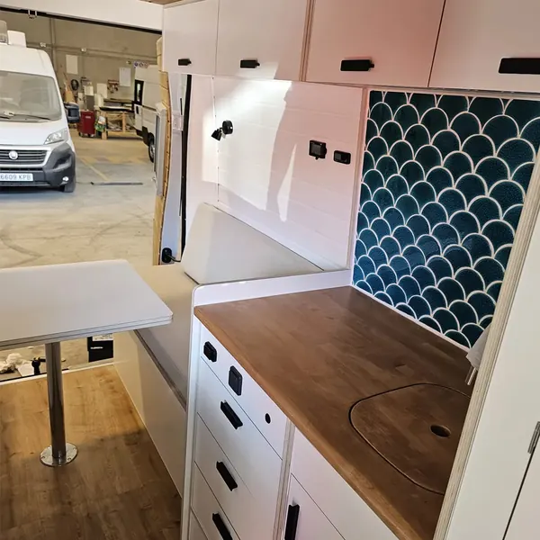 Cocina de camper con azulejo de escamas, cajones y mesa abatible