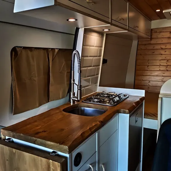 Cocina de camper con fregadero, fogón y grifo de muelle